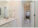 Light and airy bathroom features a marble countertop vanity and view into connecting areas at 16341 Clayton St, Thornton, CO 80602