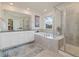 Luxury bathroom featuring double sinks, a soaking tub, and a separate glass shower at 16341 Clayton St, Thornton, CO 80602