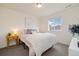 Bright bedroom features a cozy bed with a plush white blanket and a bedside table with a lamp at 16341 Clayton St, Thornton, CO 80602