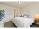 Cozy bedroom with soft gray carpet, a fluffy white blanket, and light pink bedding at 16341 Clayton St, Thornton, CO 80602