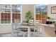 Bright dining room featuring large windows, a dining table and bench, and a stylish rug at 16341 Clayton St, Thornton, CO 80602