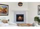 Close up of a modern fireplace with herringbone tile and a cozy fire burning at 16341 Clayton St, Thornton, CO 80602
