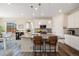 Bright eat-in kitchen featuring a center island with seating, modern appliances, and stylish pendant lighting at 16341 Clayton St, Thornton, CO 80602