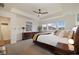 Spacious main bedroom featuring tray ceilings, a ceiling fan, and a doorway to the bathroom and laundry at 16341 Clayton St, Thornton, CO 80602