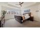 Spacious main bedroom featuring tray ceilings, a ceiling fan, and three windows at 16341 Clayton St, Thornton, CO 80602