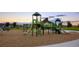 Playground area with slides, climbing structures, and a soft landing surface surrounded by grass at 16341 Clayton St, Thornton, CO 80602