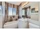 Stylish bathroom with modern wood-look tile, a sleek vanity, and a bathtub with shower, offering a luxurious spa-like experience at 384 S Decatur St, Denver, CO 80219