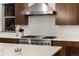 Kitchen with stainless steel stove and hood with custom cabinetry at 16370 Graham Peak Way, Broomfield, CO 80023