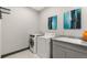 Modern laundry room featuring granite counters, sink, cabinets, washer and dryer at 16370 Graham Peak Way, Broomfield, CO 80023