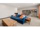Bright living area with a blue couch, built-in bookshelf, and carpeted floors at 16370 Graham Peak Way, Broomfield, CO 80023