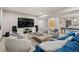 Bright living room with TV, blue sofa, gray chairs and a game table in the background at 16370 Graham Peak Way, Broomfield, CO 80023