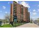 Exterior view of The Denver Tower apartments, a brick high-rise building with balconies on a sunny day at 1301 Speer Blvd # 1108, Denver, CO 80204