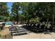 Lounging chairs lined up at the poolside, shaded by trees at 1301 Speer Blvd # 1108, Denver, CO 80204