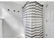 Neutral bathroom offers a modern shower with updated hardware and a stylish striped shower curtain at 6018 Owens St, Arvada, CO 80004