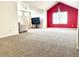 Inviting bonus room with red accent wall, large tv and plush carpeting, creating a relaxing space at 21561 E 48Th Pl, Denver, CO 80249