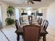 A dining room with hardwood table and chairs, with kitchen in background, illuminated by hanging chandelier at 21561 E 48Th Pl, Denver, CO 80249