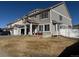 Charming two-story home featuring a covered porch, red potted plants, and a well-manicured lawn at 21561 E 48Th Pl, Denver, CO 80249