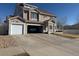 Traditional home features a 2-car garage, large driveway, and manicured lawn, enhancing curb appeal at 21561 E 48Th Pl, Denver, CO 80249