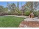 Backyard features green grass and a playhouse at the back, with stone retaining walls surrounding it at 11013 Valleybrook Cir, Highlands Ranch, CO 80130