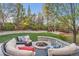 Landscaped backyard with stone fire pit, comfortable seating, lush lawn, and charming playhouse at 11013 Valleybrook Cir, Highlands Ranch, CO 80130