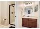 Well-lit bathroom with a stand-up shower and a modern vanity featuring a round mirror and shiplap wall at 11013 Valleybrook Cir, Highlands Ranch, CO 80130