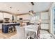 Open-concept kitchen with white cabinets, island with bar seating, and modern pendant lighting at 11013 Valleybrook Cir, Highlands Ranch, CO 80130