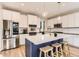 Bright kitchen with stainless steel appliances, white cabinets, a large island, and stylish pendant lighting at 11013 Valleybrook Cir, Highlands Ranch, CO 80130