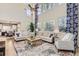 Bright living room with tall windows, comfortable seating, and an open view to the dining area at 11013 Valleybrook Cir, Highlands Ranch, CO 80130