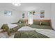 Basement bedroom with two twin beds, green bedding, and nature-themed wall art at 7746 S Gray St, Littleton, CO 80128