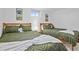 Basement bedroom with two twin beds, green bedding, and nature-themed wall art at 7746 S Gray St, Littleton, CO 80128