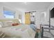 Bright bedroom with a king-size bed, a barn door to the closet, and a crib at 7746 S Gray St, Littleton, CO 80128