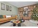 Cozy living room features a brick fireplace, a leather couch, and a coffee table with charcuterie board at 7746 S Gray St, Littleton, CO 80128