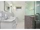 Updated bathroom with double marble vanity and glass-enclosed mosaic tile shower at 4629 Estes St, Wheat Ridge, CO 80033
