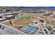 Aerial view of a recreational area with sports fields, a playground, tennis courts, and a school within a community at 3129 Open Sky Way, Castle Rock, CO 80109