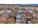 Aerial view of a light grey home that is surrounded by similar homes and is near rolling, grassy hills at 3129 Open Sky Way, Castle Rock, CO 80109