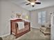 Bedroom featuring a dark wood crib, ceiling fan, neutral-toned walls and gray carpeting at 3129 Open Sky Way, Castle Rock, CO 80109