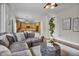 Bright living room showcases a comfortable gray sectional sofa, indoor plants, and hardwood floors at 3129 Open Sky Way, Castle Rock, CO 80109