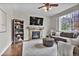 Inviting living room features a stone fireplace, cozy sofa, bookshelves, and large window allowing natural light at 3129 Open Sky Way, Castle Rock, CO 80109
