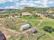 Panoramic aerial shot of a home with outbuildings, fencing, and a scenic mountain backdrop at 5285 E State Highway 86, Franktown, CO 80116