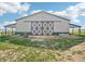 Expansive barn with a prominent sliding door on a sunny day with green grassy surroundings at 5285 E State Highway 86, Franktown, CO 80116