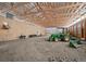 Vast barn interior with high ceilings, natural wood supports, and green tractor at 5285 E State Highway 86, Franktown, CO 80116