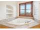 Soaking tub with a tile surround and a window offering views of the outdoors at 5285 E State Highway 86, Franktown, CO 80116