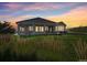 Inviting outdoor space with a covered patio, lush lawn, and sunset views at 5285 E State Highway 86, Franktown, CO 80116