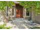 Inviting front entrance with stone accents, double doors, and lush landscaping at 5285 E State Highway 86, Franktown, CO 80116