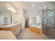 Bright primary bathroom features dual sinks, soaking tub, glass shower, and built in shelves at 5285 E State Highway 86, Franktown, CO 80116