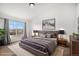 A staged bedroom with a large window providing natural light and a plush rug for added comfort at 1509 S Florence Ct # 218, Aurora, CO 80247