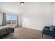 Bedroom featuring a large window, neutral carpet, and a cozy blue loveseat at 1509 S Florence Ct # 218, Aurora, CO 80247