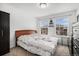Bright bedroom featuring two large windows, a bed, and a dark wardrobe at 1509 S Florence Ct # 218, Aurora, CO 80247