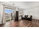 Bright living room with hardwood floors, plenty of light from the large windows, and a leather couch at 1509 S Florence Ct # 218, Aurora, CO 80247