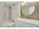 Charming bathroom features stylish wallpaper, a round mirror, and a shower/tub combo at 14001 E Marina Dr # 603, Aurora, CO 80014